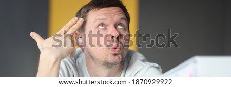 Dumbfounded man looks up next to folder with documents. Time management in business concept