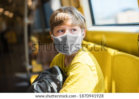 Boy yellow shirt gray protective mask in the train