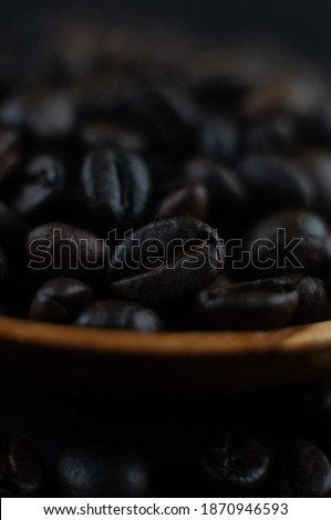 Biji Kopi or Coffee beans on wooden plate. Close up view. 