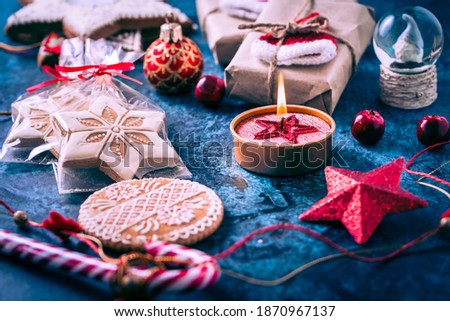  Christmas candle with gingerbread cookies, decorations and ornament on blue background