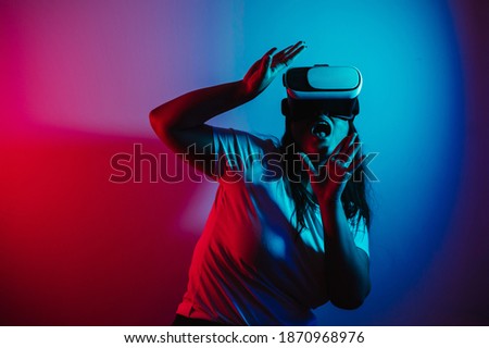 Gamer girl using vr glasses to play videogames. Woman playing videogames with virtual reality technology 