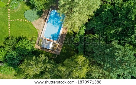 Swimming pool in beautiful garden aerial top view
