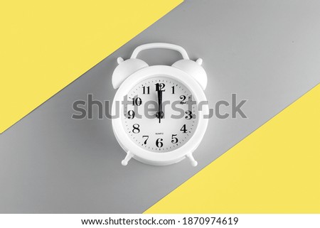 alarm clock on Ultimate Gray and Illuminating yellow background in copy space. bright color style of the year 2021