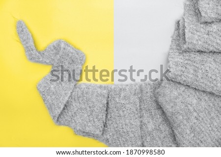 knitted scarf in trendy color of the 2021 ultimate grey. Gray winter acсessories. illuminating yellow backgound. knitwear for kids. female trendy bactus scarf. 
