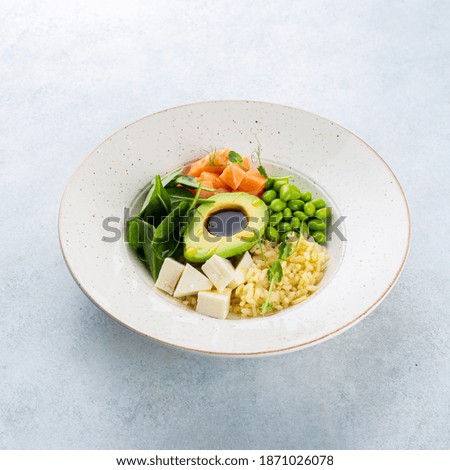 Top view of poke bowl with salmon and avocado on white background