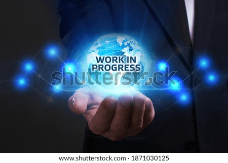 Business, Technology, Internet and network concept. Young businessman working on a virtual screen of the future and sees the inscription: Work in progress