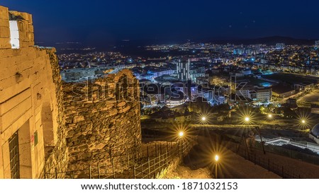 Aerial view from old castlethe in historical city town of Nevsehir night timelapse. Panoramic skyline with illuminated buildngs and walls with lights