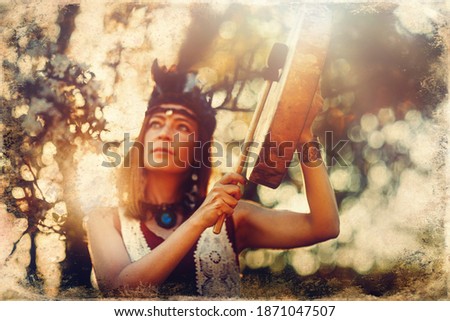 beautiful shamanic girl playing on shaman frame drum in the nature. Old photo effect.