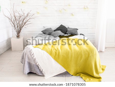 light, white, spacious bedroom with a large bed, in the Scandinavian style. Color of the year 2021