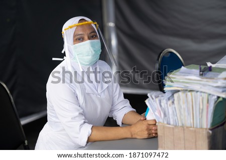 Female frontliner performing her tasks during the coronavirus pandemic. Royalty-Free Stock Photo #1871097472
