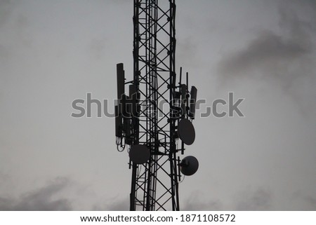 A tower of telephone in distance in the dusk time. Dark clouds are surrounded everywhere upon the sky