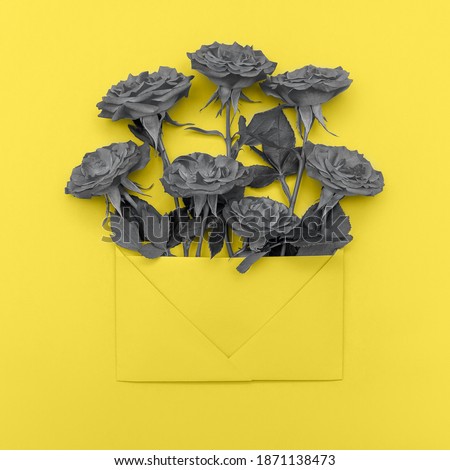 Demonstrating trendy colors 2021 - Gray and Yellow. Bouquet of grey roses in yellow envelope against yellow background. Mock up, flat lay, top view, copy space.