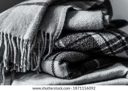 Stack of woolen checked blankets, autumn and winter concept, gray image with trendy color of 2021