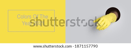 Yellow glove in grey hole background. Trendy banner with color Ultimate Grey and Illuminating of the 2021 year.