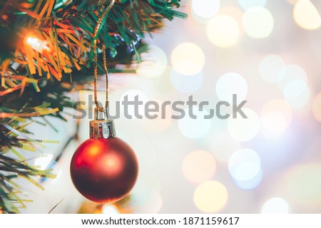 Christmas decoration. Red balls hanging on pine branches Christmas tree garland and ornaments over abstract bokeh background with copy space