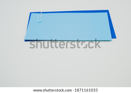 A closeup shot of pieces of paper attached with a paper clip on a gray background