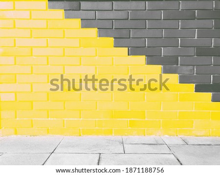 Abstract bright illuminating yellow and gray colours of wall brick as background. Trendy colors of the year 2021 - Gray and Yellow. 