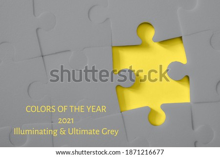 Multiple grey puzzle pieces put together without one piece on yellow background. Colors of year 2021. Place for text.