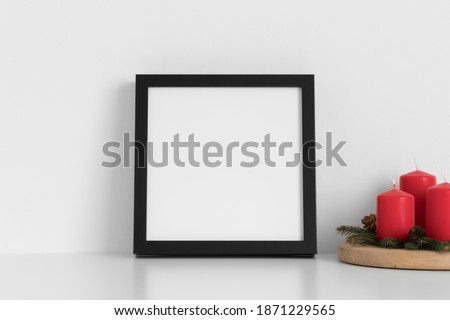 Black square frame mockup with candles. Christmas decoration