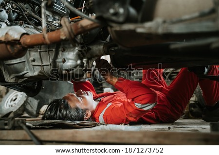 portrait of young asian man repairing a broken car engine part