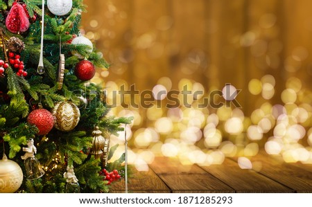 Fir Tree decorated with christmas balls on rustic wood and sparkles light backgorund 