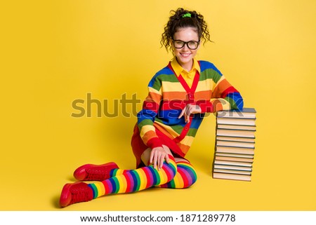 Photo attractive student lady sitting floor lean many book pile wear striped rainbow clothes isolated yellow color background