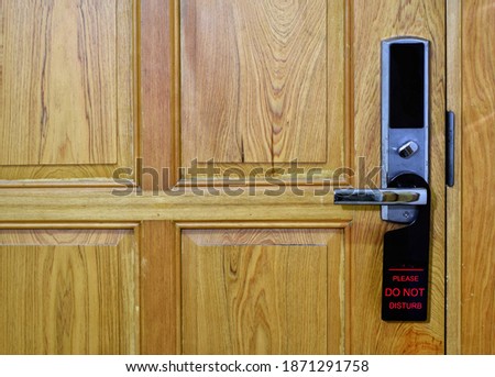 A hotel room door with a do not disturb sign on the door.