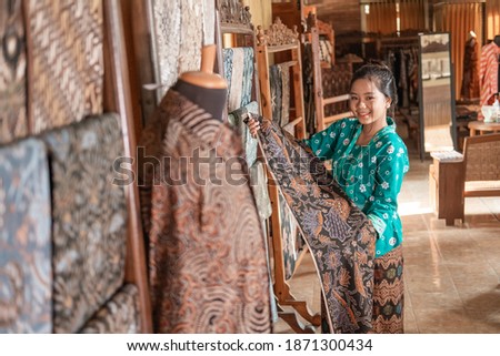 portrait of young customer service in traditional indonesian batik store Royalty-Free Stock Photo #1871300434