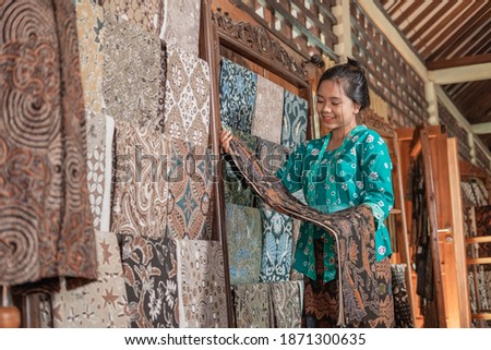 portrait of young women selling traditional batik cloth and clothes Royalty-Free Stock Photo #1871300635