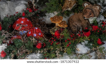 Christmas toy in the form of mushrooms, birds and fox. Decorated christmas tree background.