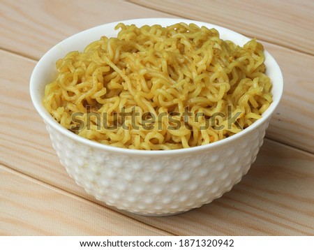 Maggie Noodles, Instant Noodles served in a bowl over a rustic wooden background, selective focus