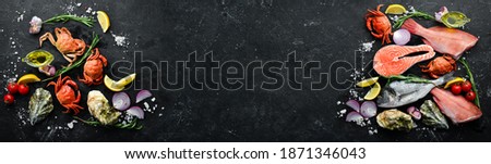 Seafood. Set of fish, crustaceans, oysters, mussels and seafood on a black stone background. Free space for your text. Royalty-Free Stock Photo #1871346043