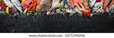 Seafood. Set of fish, crustaceans, oysters, mussels and seafood on a black stone background. Free space for your text. Royalty-Free Stock Photo #1871346046