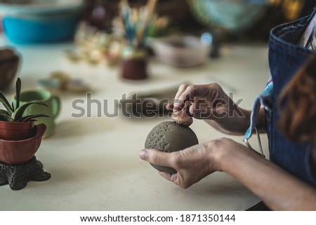 Close up of a woman making ceramic and pottery work with clay - Pattern stamp