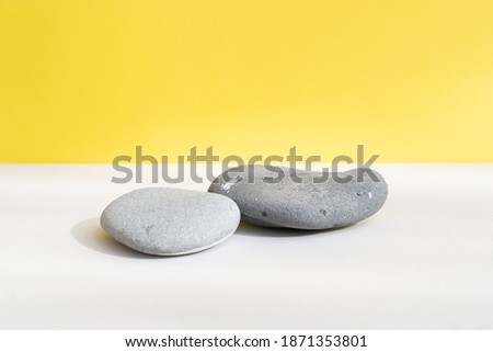 Minimal modern product display on textured gray and yellow background with shadows