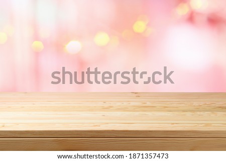 Empty wooden table over pink bokeh lights background. Valentine's day or women day concept celebration.