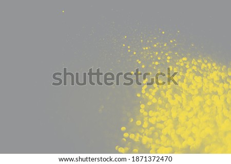 Blurred yellow sparkles on the grey background. Trendy colors. Yellow and Gray. Demonstrating Color 2021.