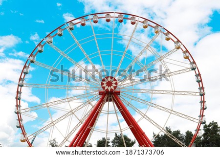 ferris wheel in summer on a background of blue sky with clouds