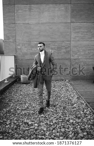 Full length body size photo of man walking on stones wearing plaid suit isolated grey color background