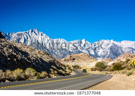 Mt Whitney, California, USA. Snowy peaks of the tallest mountain in the contiguous United States and the Sierra Nevada. Empty road on a scenic route. 