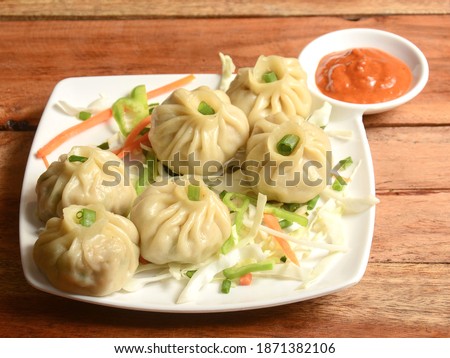Veg steam momo. Nepalese Traditional dish Momo stuffed with vegetables and then cooked and served with sauce over a rustic wooden background, selective focus Royalty-Free Stock Photo #1871382106