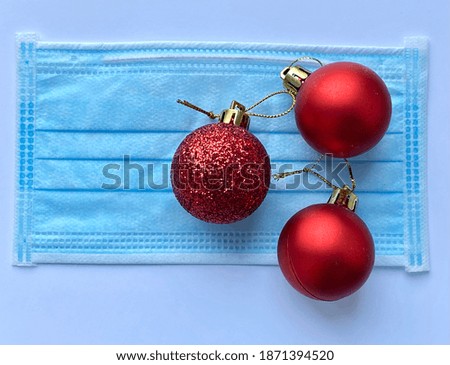 Medical Christmas protective face mask with winter decorations on white background with red balls 