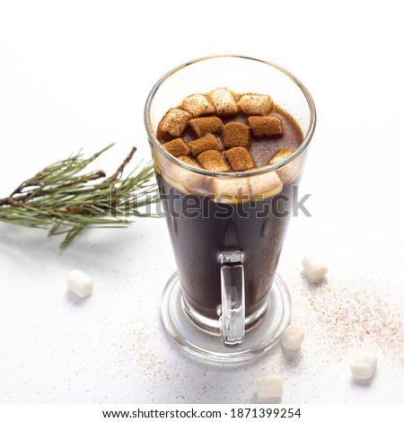 Hot coffe with marshmallows in transparent tall glass, isolated on white background.