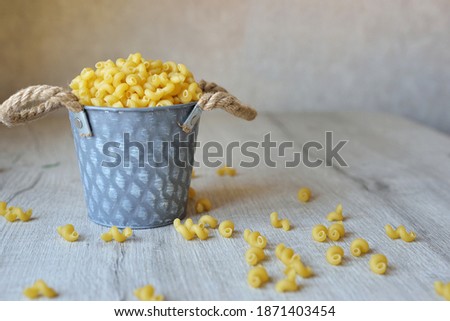 Raw noodles pasta rolls in a decorative bucket on the kitchen table. with space for text Menu serving size. mockup, Space for text, Copyspace