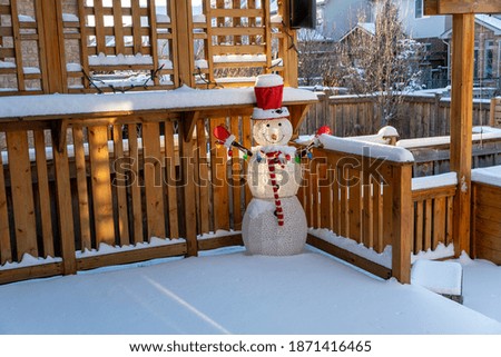 The snowman is set in the yard in the snow and prepared for the New Year celebration