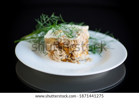 slice of chilled jellied meat in a plate on a black background