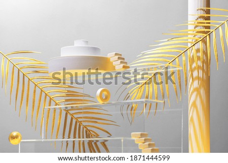 Monumental composition with catwalks, stairs, palm leaves and geometric shapes in blue and gold colors, beauty concept, mock up, color 2021