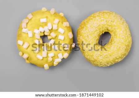 Colors of year 2021. Gray and Yellow. Two donuts with icing on pastel background. Sweet donuts.