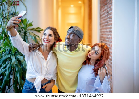 Three friends take a picture hugging and smiling