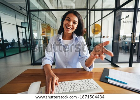 Expressive beautiful lady having a video-call at work Royalty-Free Stock Photo #1871504434